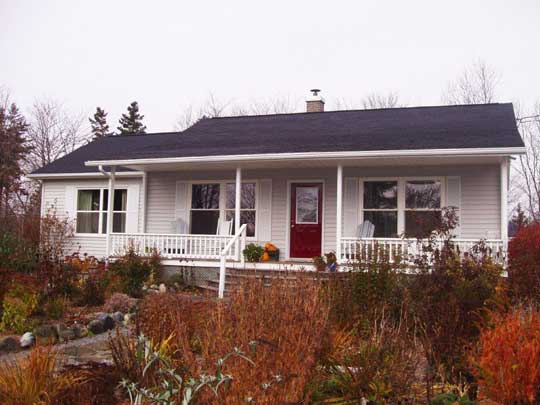 Compact new bungalow with side entrance, and front porch with roof.