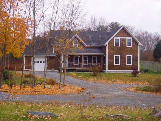Large two storey, new house, with wood shingle siding, neat white trim and attached garage