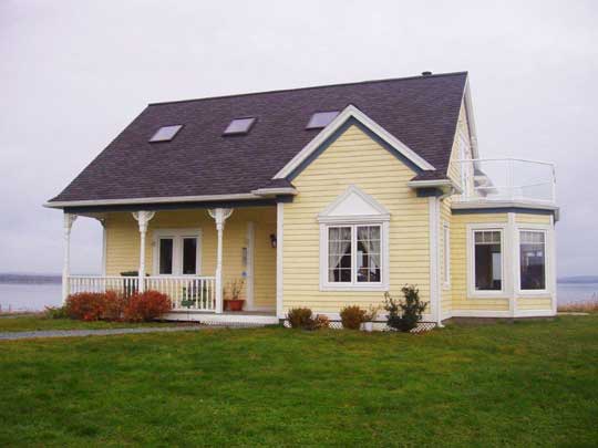 New home built in older style with heavy window trim and fascia, gingerbread details, a sitting room with bay windows