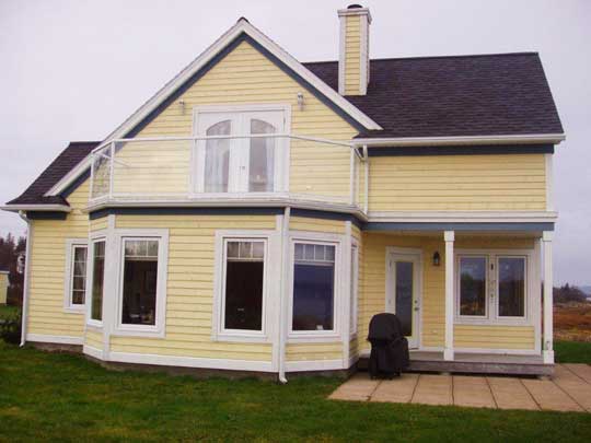 New home features second floor deck with glass railing to provide unobstructed view of the ocean