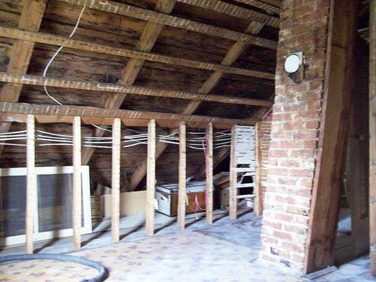 Interior view of attic space of Cape Cod home with new wiring; old plaster already removed