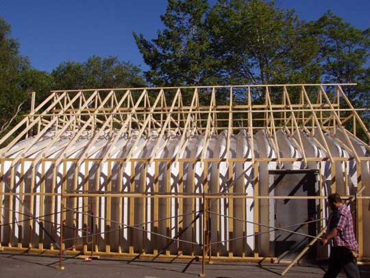 Side view of wall framing and roof trusses of renovation job to coverup existing Quonset hut